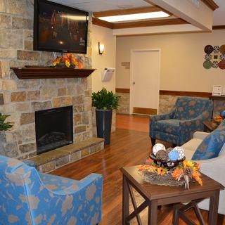 A cozy living room with a stone fireplace, a mounted TV, and comfortable seating.