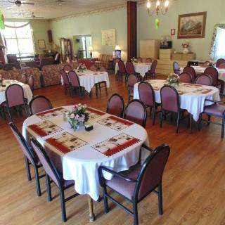An elegantly arranged dining area with neatly set tables and chairs, ready to welcome guests.