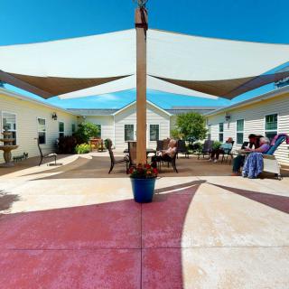 An inviting courtyard with sail shades and comfortable seating, perfect for relaxation on a sunny day.