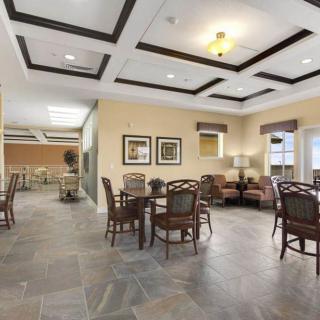 A spacious and elegantly furnished lounge with seating arrangements and decorative lighting.