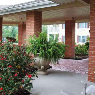 A peaceful garden walkway with lush greenery and brick columns.
