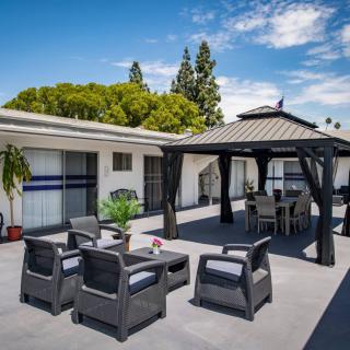A spacious outdoor patio featuring comfortable seating and a gazebo, perfect for relaxation.