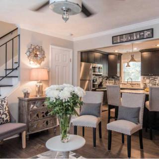 A modern living space with an open kitchen and dining area, elegantly decorated with neutral tones and stylish furniture.