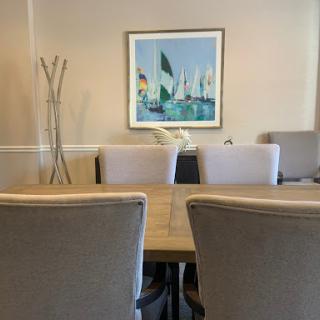 A modern conference room featuring a large table, comfortable chairs, and a colorful artwork on the wall.