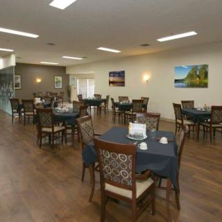 A spacious dining area with neatly arranged tables and chairs, adorned with wall art.