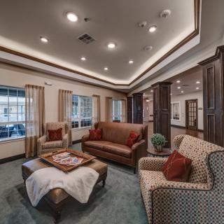 A cozy living room with sofas, armchairs, and a coffee table arranged under soft lighting.