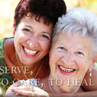 Two women smiling together outdoors, showcasing friendship and care.