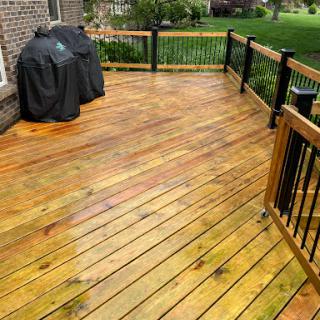 A well-maintained wooden deck with a grill cover, perfect for outdoor gatherings.