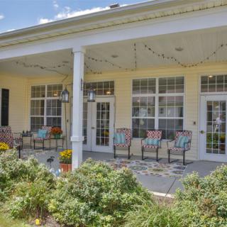 A cozy porch with chairs and plants, perfect for relaxing outdoors.
