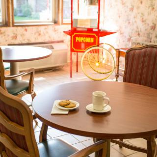 A cozy cafe interior with a table set for coffee and a popcorn machine in the background.