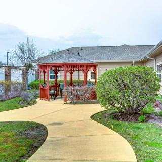 A landscaped garden with a winding pathway leading to a red gazebo.
