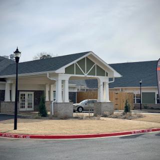 A modern building featuring a welcoming entrance and a parking area.