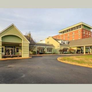 A building complex with a driveway and entrance, featuring both modern and traditional architectural elements.