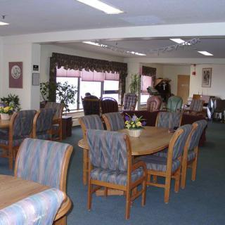 A spacious communal dining area with tables and chairs arranged for group seating.