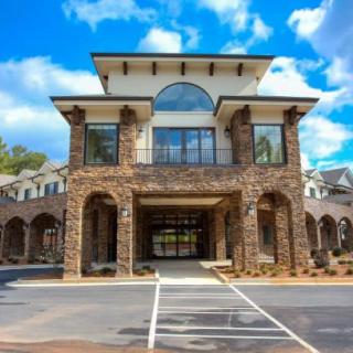 A stone facade building with large pillars and a grand entrance under a blue sky.