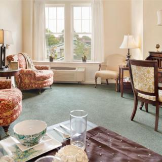 A cozy living room featuring elegant furniture and a large window letting in natural light.