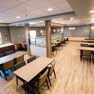 A spacious and modern dining area with neatly arranged tables and chairs.