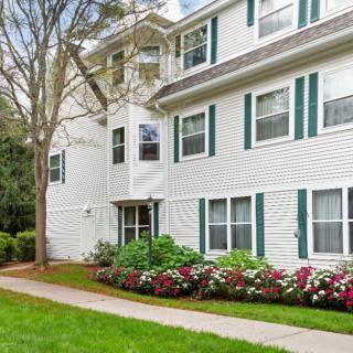 A well-maintained apartment building with lush green landscaping and vibrant flowers.