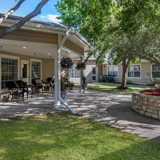A serene outdoor patio area surrounded by trees and greenery.