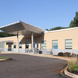 A modern building with a sleek design and an inviting entrance on a clear day.
