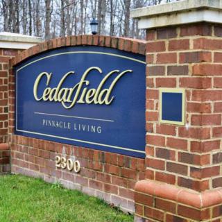 Entrance sign for Cedarfield, a premier living community.