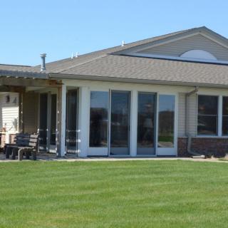 A single-story residential house with large windows and a neatly maintained lawn.