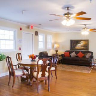 A cozy living room with a dining area featuring wooden furniture and a comfortable sofa.
