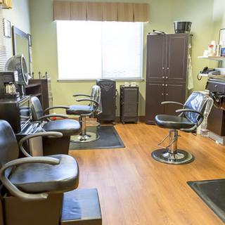 An interior view of a hair salon with multiple styling chairs and mirrors.