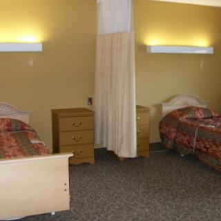 A hospital room with two beds and a curtain divider.