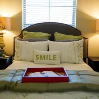 A cozy bedroom with decorative pillows and warm lighting.