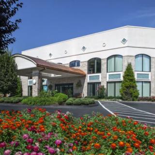 A well-maintained building entrance surrounded by vibrant flowers and greenery.