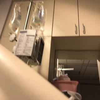 A hospital room with intravenous bags and medical equipment.