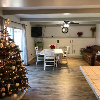 A cozy living room with a beautifully decorated Christmas tree and dining area.