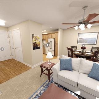 A cozy living room with an adjoining dining area and kitchen, featuring a ceiling fan and comfortable seating.