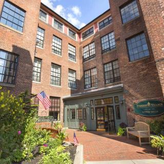 Entrance to a brick building with flags and garden area.