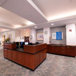 Interior view of a lobby with a reception desk and artwork on the walls.