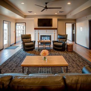 A cozy living room with modern furnishings and a central fireplace.