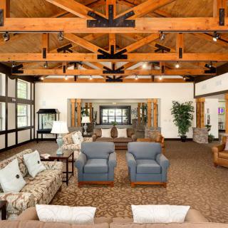 A spacious living room with comfortable seating and exposed wooden beams.