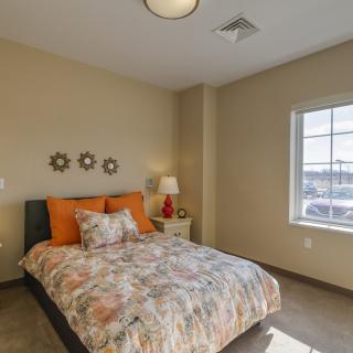 A cozy bedroom with a decorated bed and a window view.