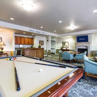 A well-appointed game room featuring a pool table, comfortable seating, and a television.