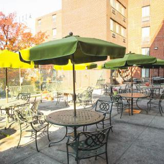 A cozy outdoor seating area with green umbrellas and tables, perfect for enjoying a sunny day.