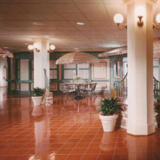 Spacious lobby interior with seating and decorative plants.