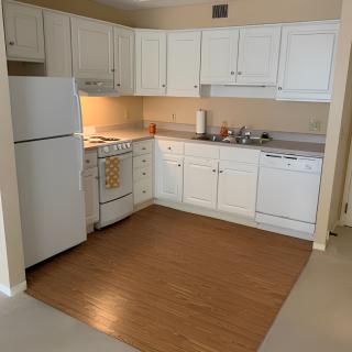 A kitchen with white cabinets, a refrigerator, stove, oven, and dishwasher.