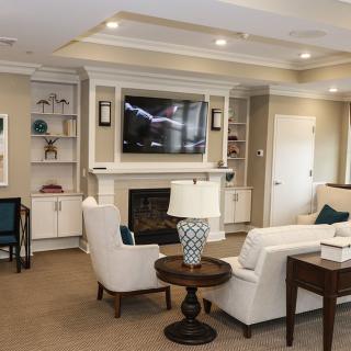 A cozy living room with comfortable seating, a fireplace, and a wall-mounted TV.