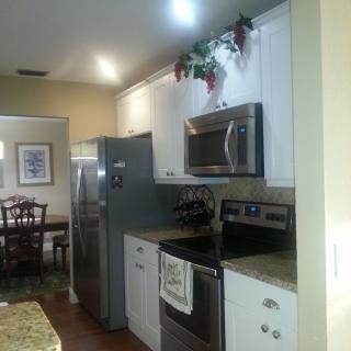 A modern kitchen with stainless steel appliances and a view into the dining area.