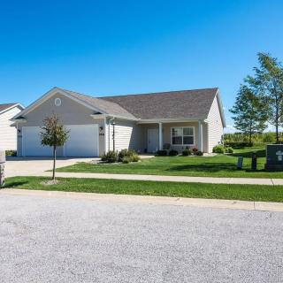 A suburban single-story house with a well-maintained lawn and driveway.
