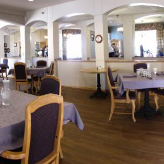 A cozy and elegantly decorated restaurant dining area with neatly arranged tables and chairs.