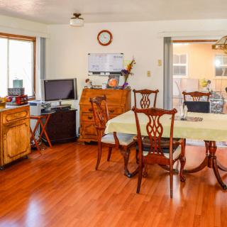 A cozy dining room with wooden flooring and classic furniture.