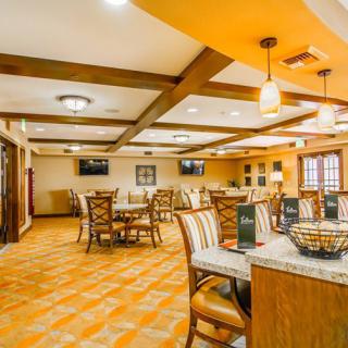 A cozy dining area with warm lighting and neatly arranged tables and chairs.