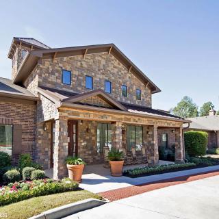 A suburban brick house with well-maintained landscaping.